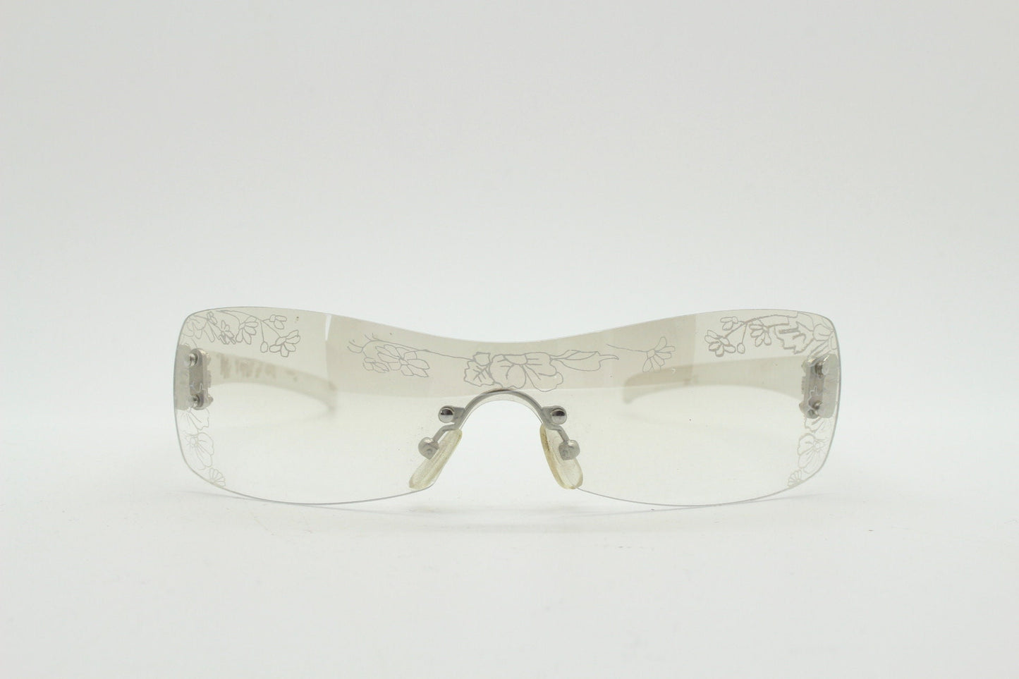 Y2K vintage visor sunglasses. Frameless 2000's wraparound mini mask shield design with light tone mirror mono lens and flower print. 00s NOS