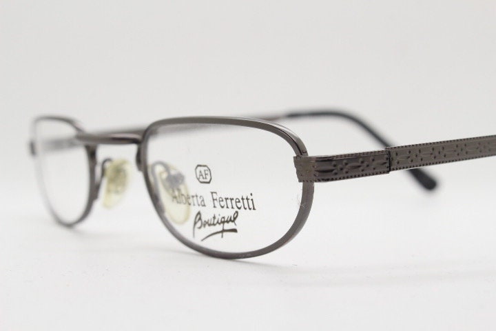 Alberta Ferretti 90s vintage oval eye glasses made in Italy. Small grey metal optical frame with ornate arm pattern. Prescription RX. NOS