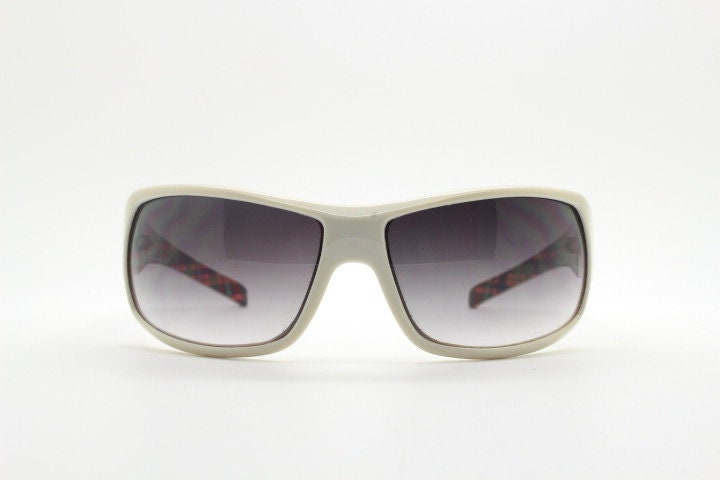 Uvex Y2k vintage wrap around bug eye sunglasses. Curving white sports shield frame with black lenses and tartan interior. Rave 2000s. NOS
