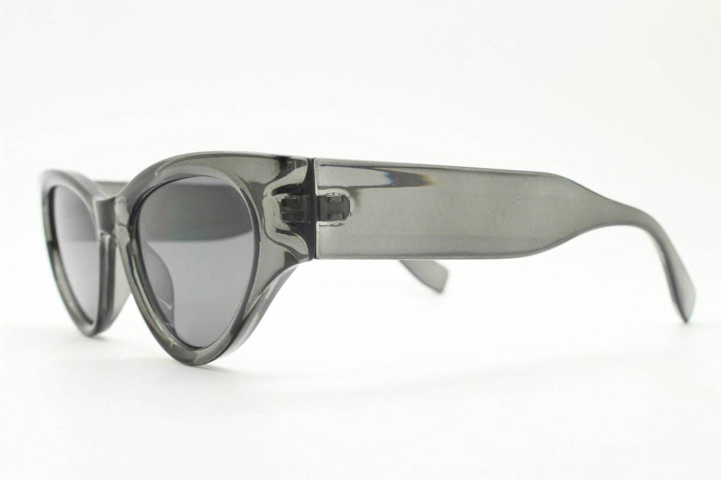 Thick cateye sunglasses with cropped sides and sharp outline. Womens 60s design chunky transparent grey frame and lenses. Y2k vintage