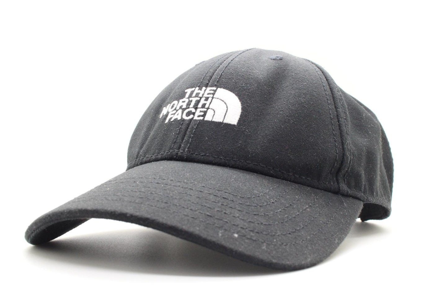 The North Face plain black baseball cap with white spell out logo. Classic trucker style hat with fully adjustable back. One size