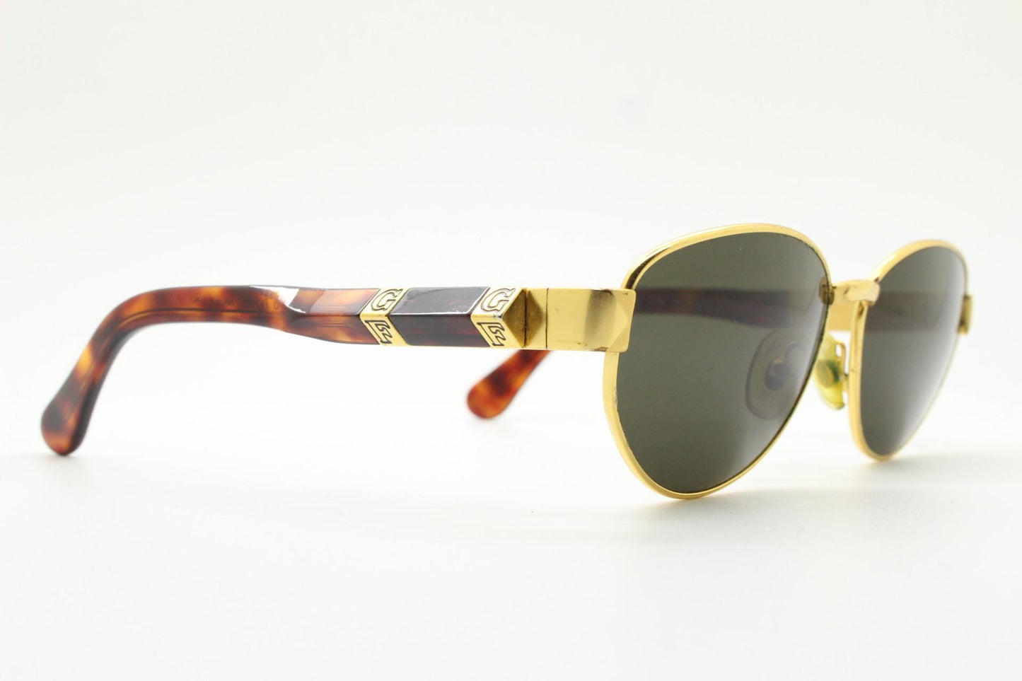 Gianfranco Ferre oval sunglasses made in Italy. Gold frame with triangular tortoise acetate arms and green lenses. 90s vintage GFF
