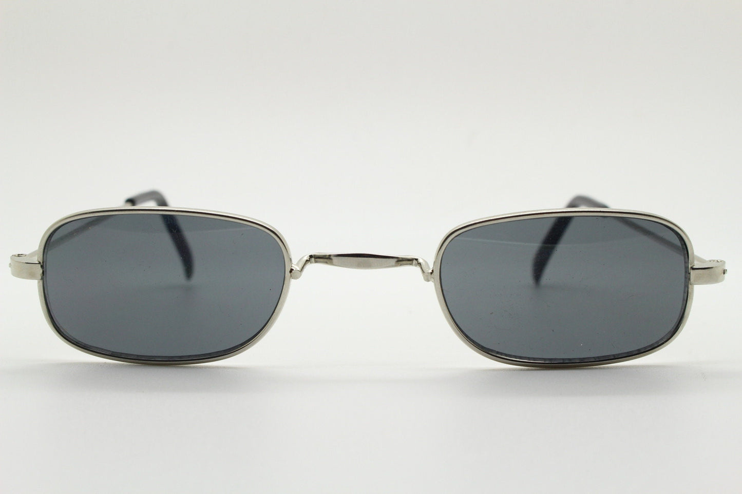 80s vintage rectangular low profile metal sunglasses. Minimal 60s mens mod design in silver chrome frame with grey lenses. NOS
