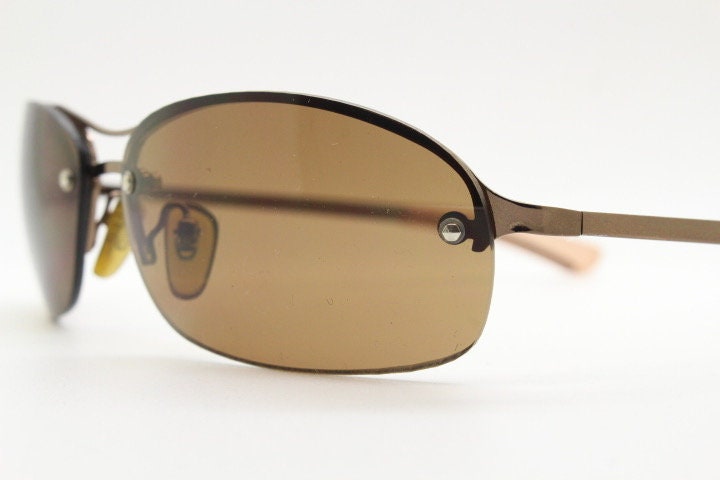 Y2K vintage oval aviator sunglasses. Metallic brown chrome half frame with mid tone curved bug eye lenses and straight arms. 2000's. NOS