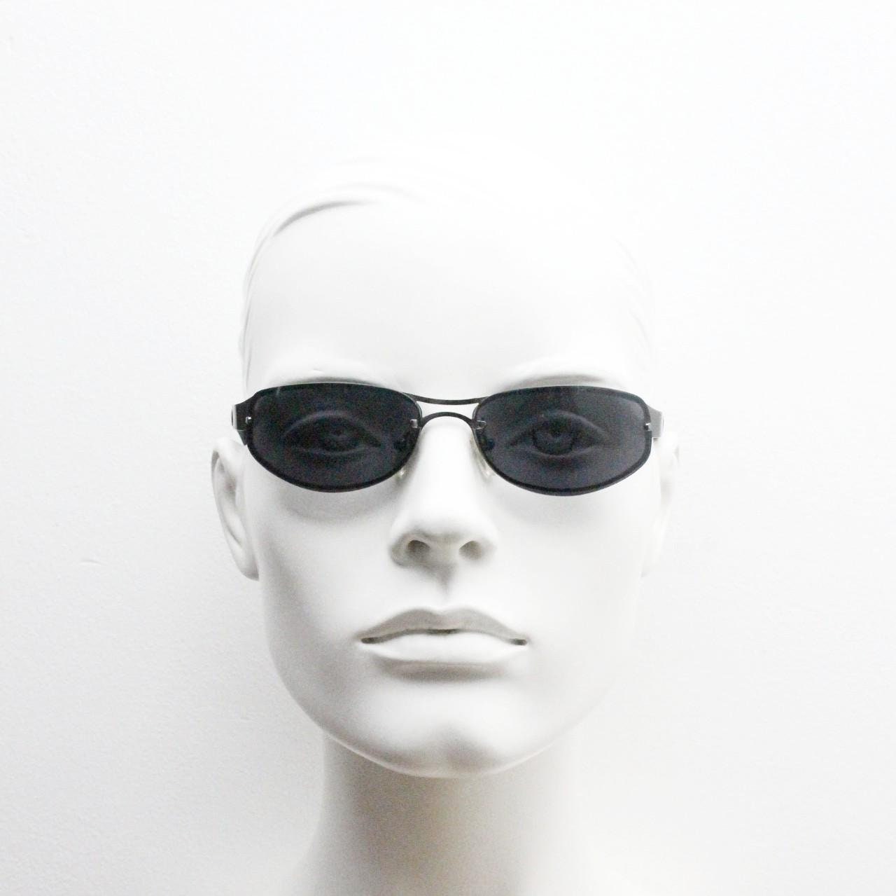 Y2K vintage small bug eye oval sunglasses. Gunmetal grey chrome metal frame with curved bug eye lenses and matt black arms. 2000's NOS