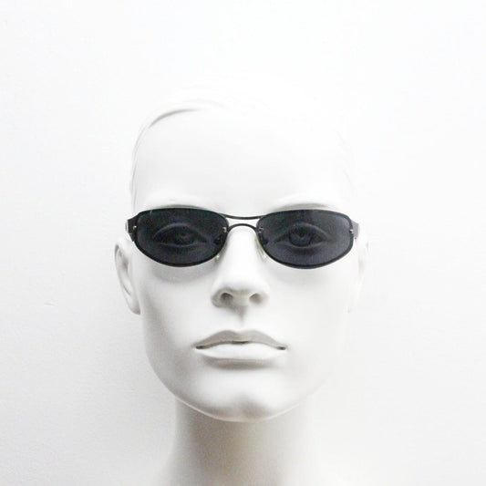 Y2K vintage small bug eye oval sunglasses. Gunmetal grey chrome metal frame with curved bug eye lenses and matt black arms. 2000's NOS