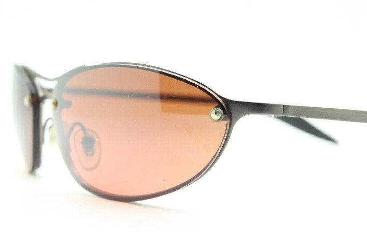 Y2K vintage oval sunglasses. Satin finish grey metal frame with amber curved almond bug eye lenses and straight arms. 2000's. NOS