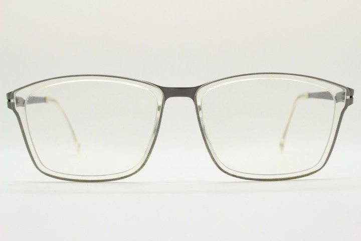 Modo rectangular eye glasses made in Japan. Matt grey titanium optical frame encasing transparent crystal acetate front. Prescription RX