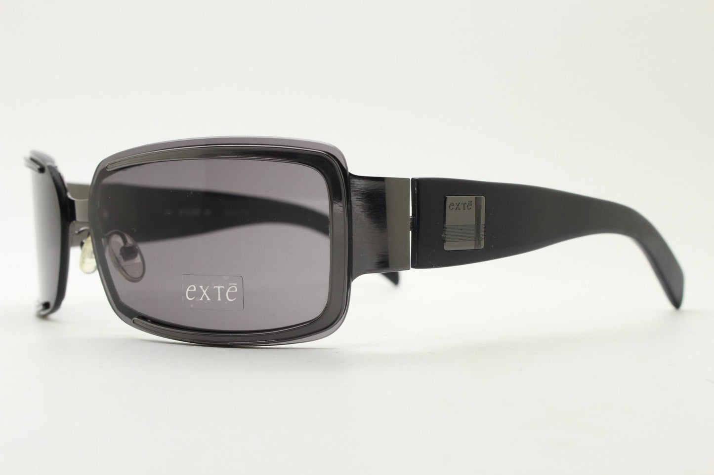 Exte wrap around 90s vintage sunglasses made in Italy. Grey metal front with black acetate arms and curved lenses in neat proportions. BNWT