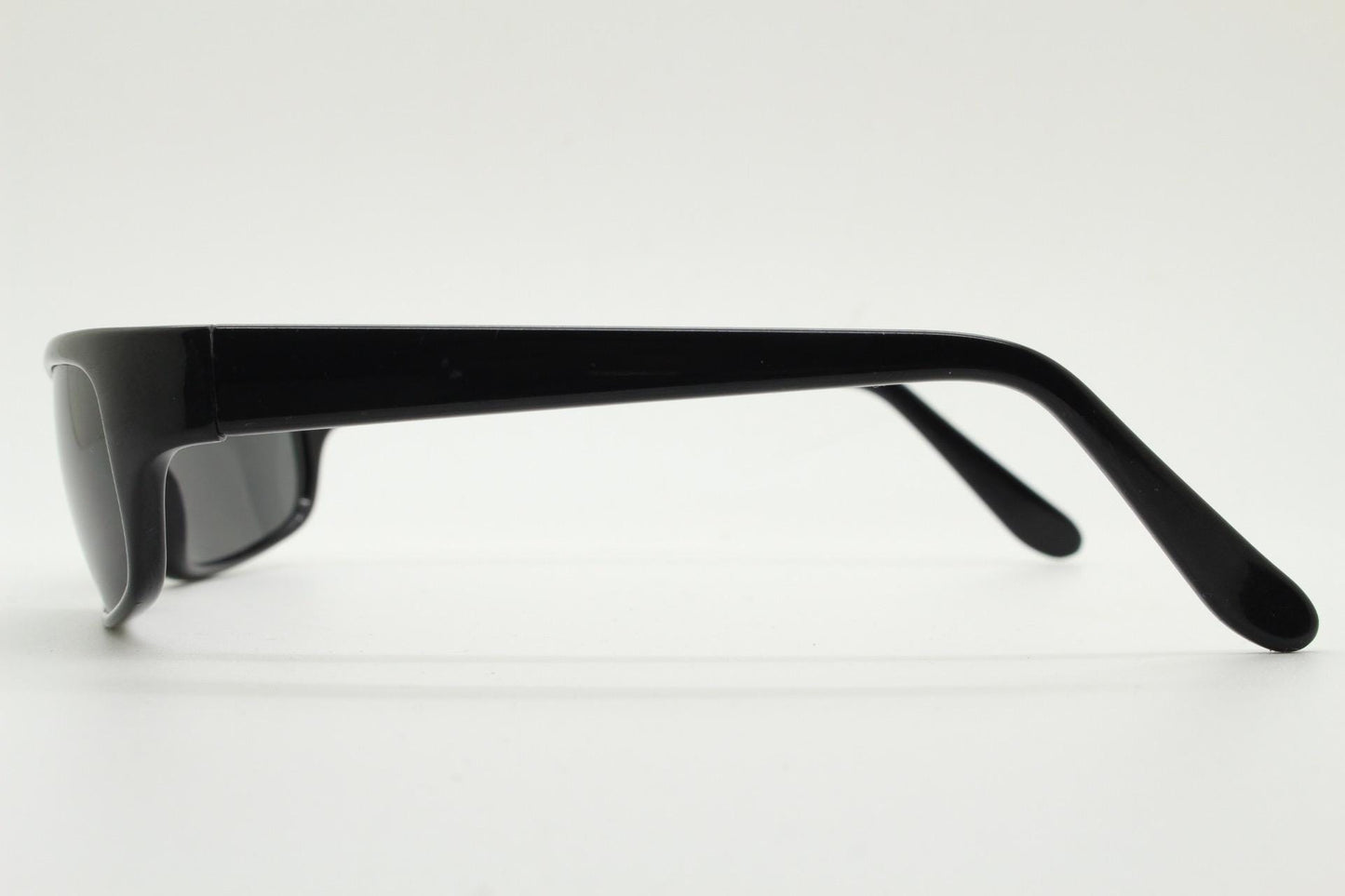 90s vintage curved wraparound sunglasses. Aerodynamic low profile plain black gloss curved cat eye frame. Minimal shield design. NOS
