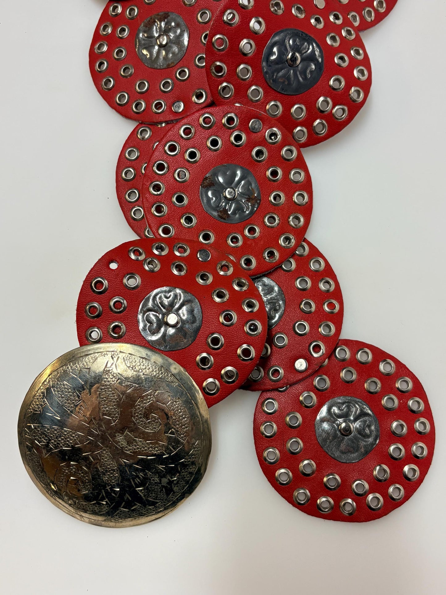 80s vintage womens huge red leather circles belt. Versatile statement piece with holed studs, metal discs and big 'shield' buckle. NOS