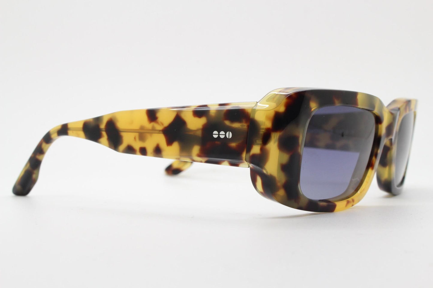 Komono chunky rectangular sunglasses model The Wes. Thick framed honey tortoise eco acetate with curved back 'goggle' sides and tall arms.