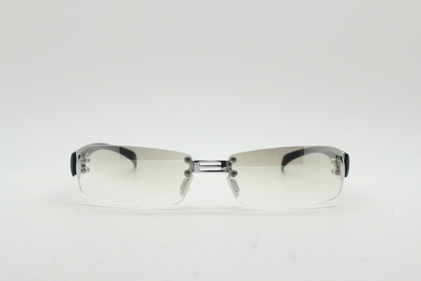 Y2K vintage frameless sunglasses. Silver chrome trim with patterned arms and extra light tone graduated curved mirror lenses. 2000's. 90s