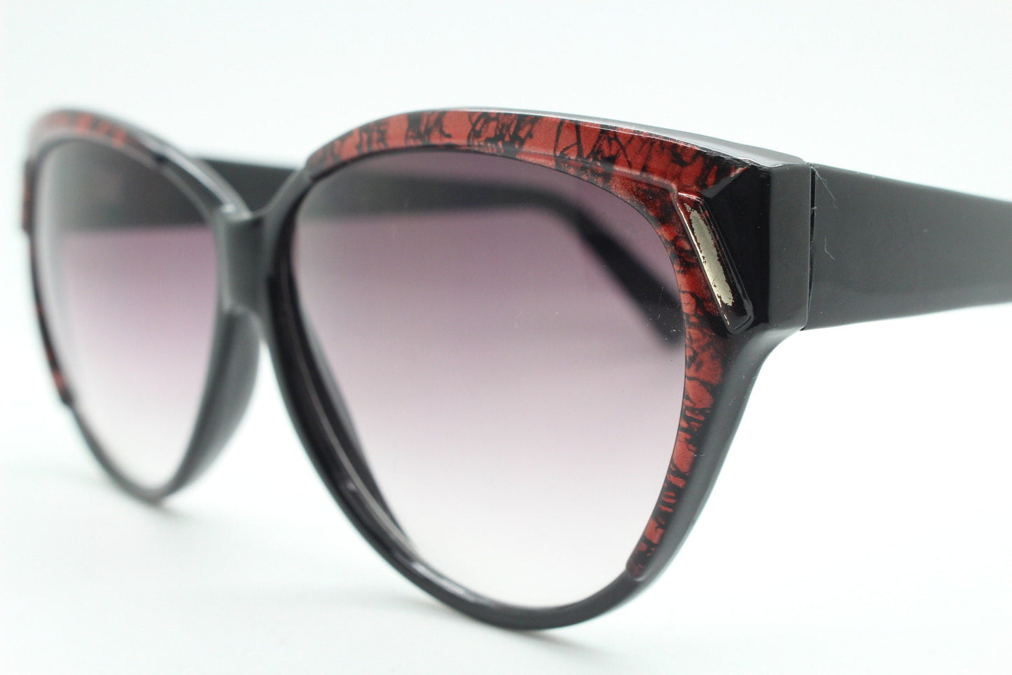 80s vintage oversized cateye sunglasses. Women's black cat eye frame with red patterned brow and sizzling gradient lenses