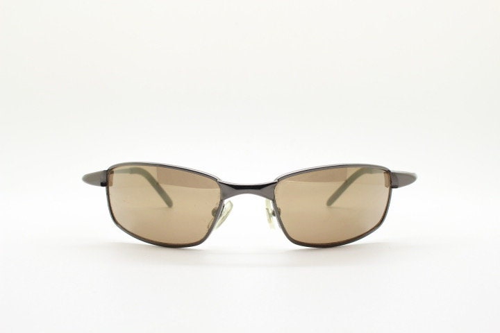 90s vintage curved rectangular sunglasses. Solid metal low profile frame in brown chrome with slightly mirrored lenses. 2000's. Y2K NOS