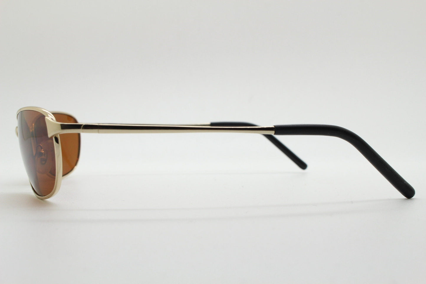 90s vintage curved angular oval sunglasses. Solid metal small bug eye frame in gold chrome with mid tone brown lenses. 2000's. Y2K NOS