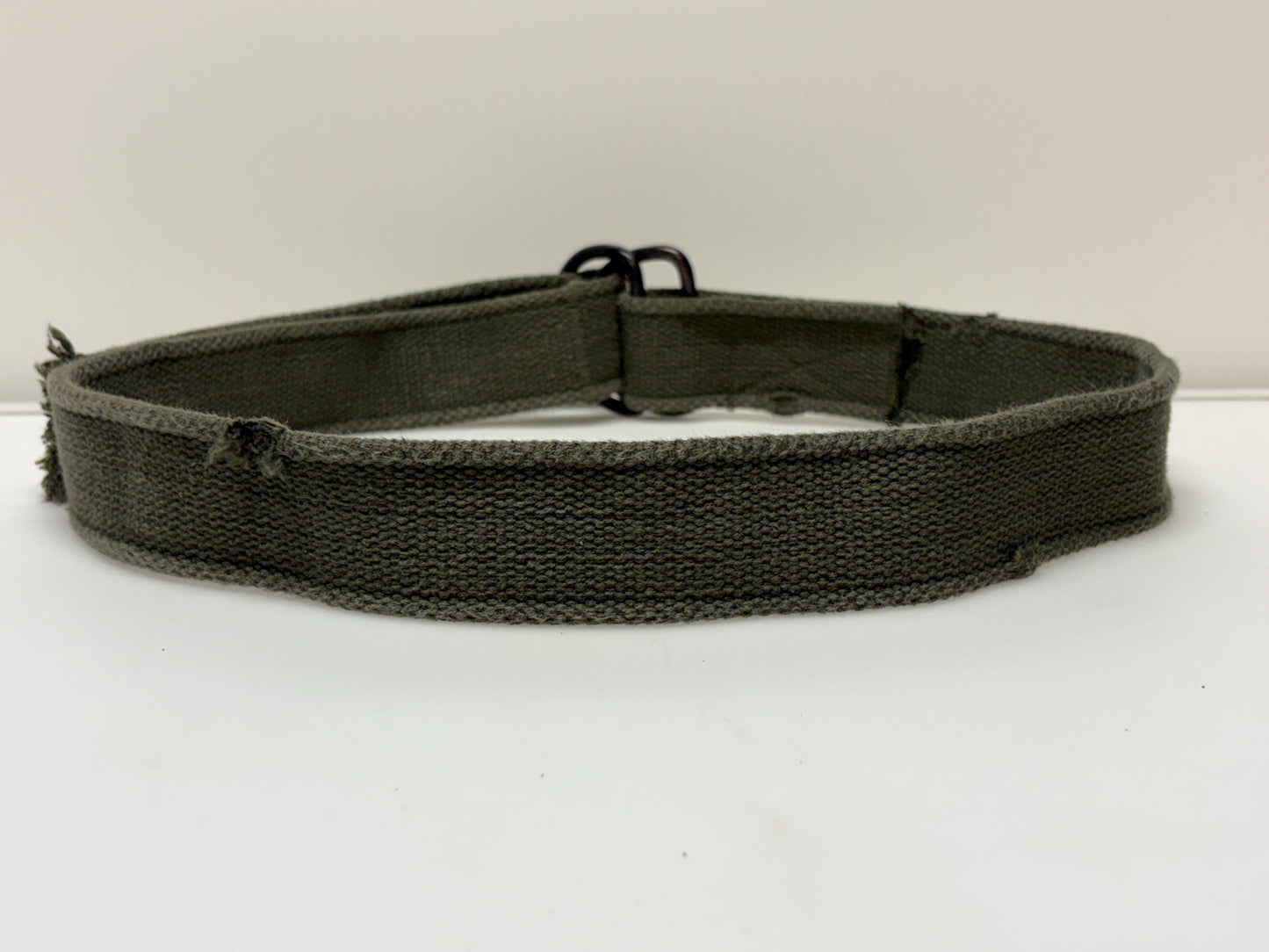 90s vintage genuine army belt. Thick woven canvas in green. Distressed look. Metal looping backwards buckle. Fully adjustable. Webbing