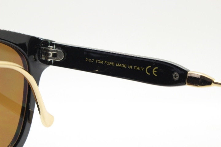 Tom Ford vintage wayfarer design sunglasses made in Italy. Slightly cat eye form in plain black gloss acetate with gold arms