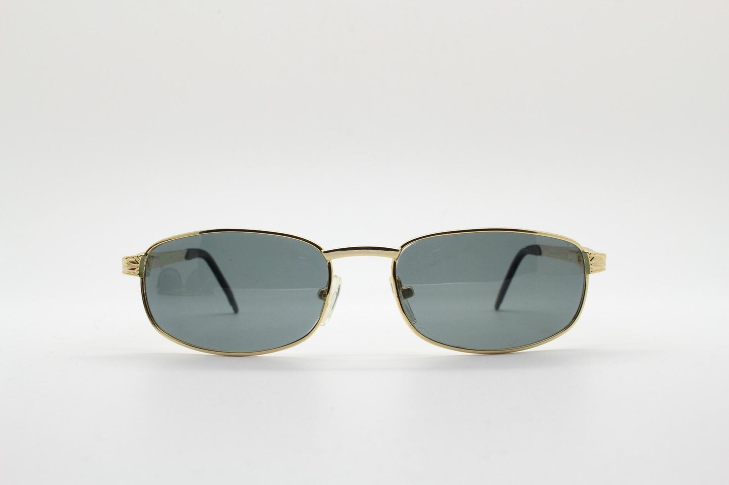 90s vintage low profile gold rectangular sunglasses. Solid metal frame in a shiny chrome finish embossed arm pattern and green lenses. NOS