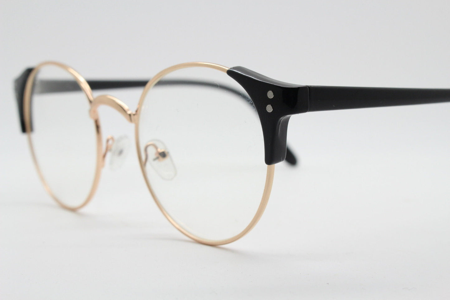 90s vintage modified cat eye glasses. Black arms with a round gold face. 40s, 50s style clear lens eyeglasses. Cateye