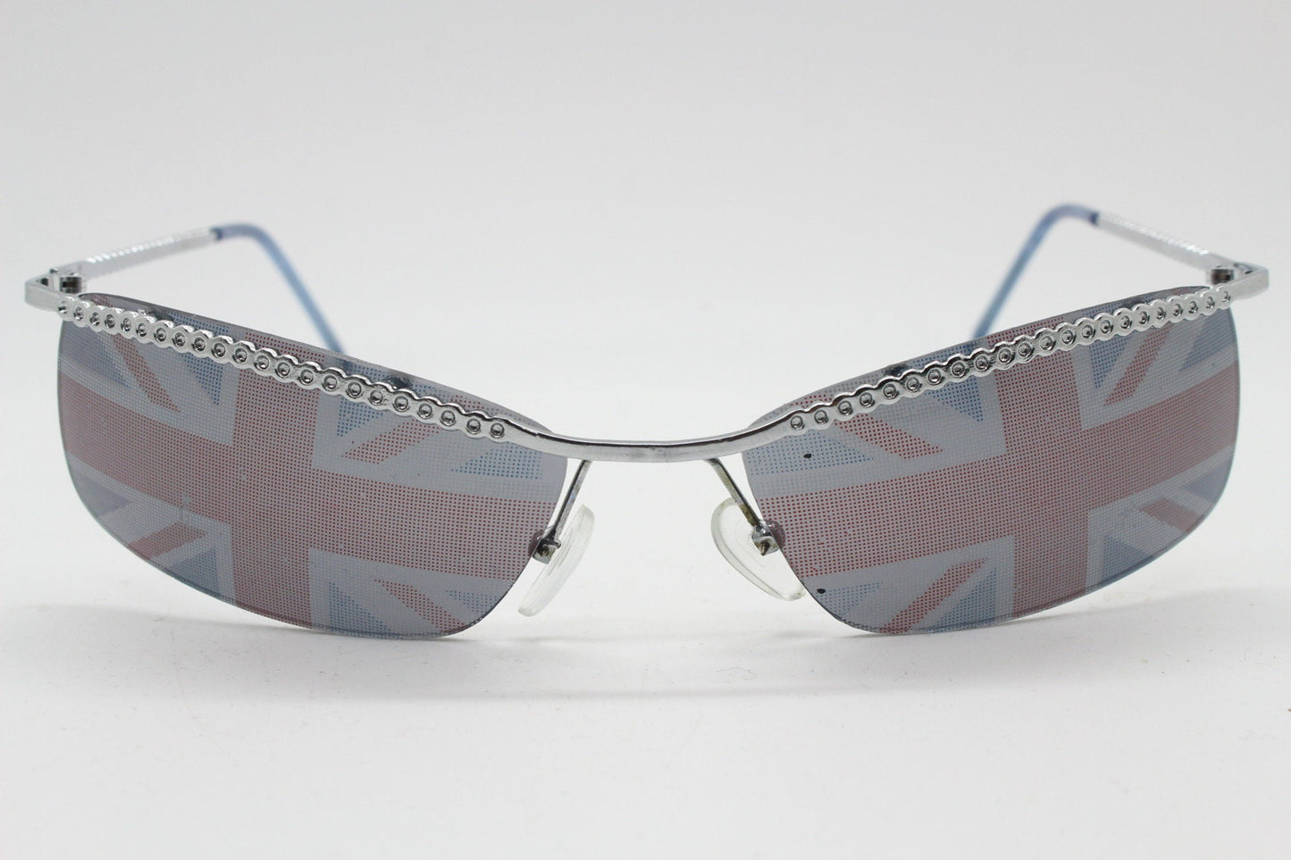 90s vintage half frame Union Jack sunglasses. Curved lens suspended on a sparkling chrome brow. Unused NOS. Brit pop girl power