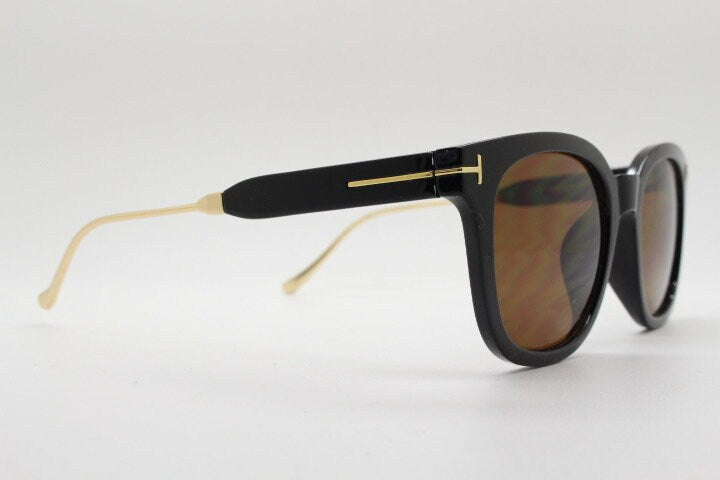 Tom Ford vintage wayfarer design sunglasses made in Italy. Slightly cat eye form in plain black gloss acetate with gold arms