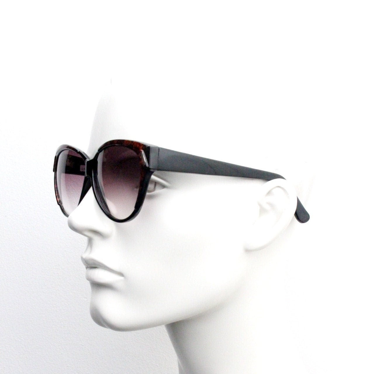 80s vintage oversized cateye sunglasses. Women's black cat eye frame with red patterned brow and sizzling gradient lenses