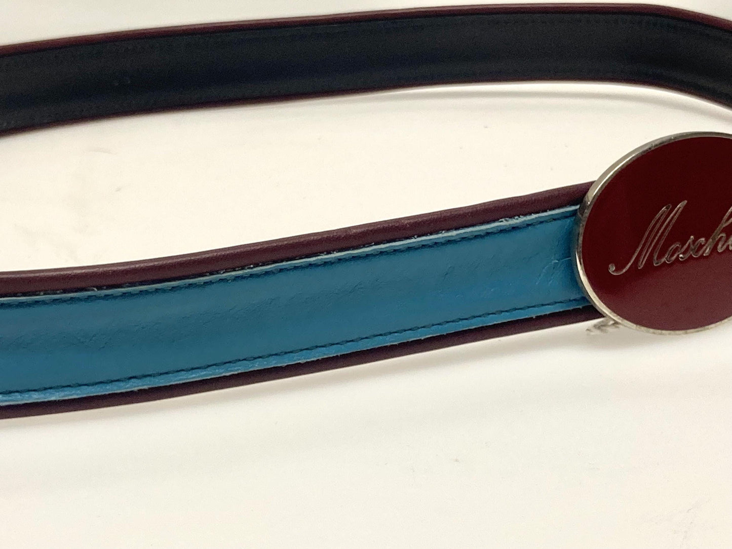 Moschino 90s vintage womens dress belt in oxblood and blue genuine leather with oval enamelled metal buckle. Made in Italy. BNWT. NOS
