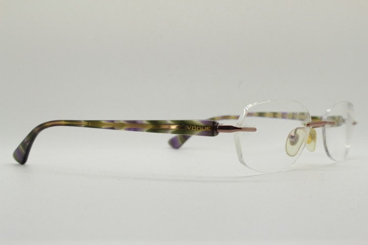 Vogue vintage frameless oval eye glasses. Transparent acetate arms with purple and green tones. Minimal Prescription RX Optical frame