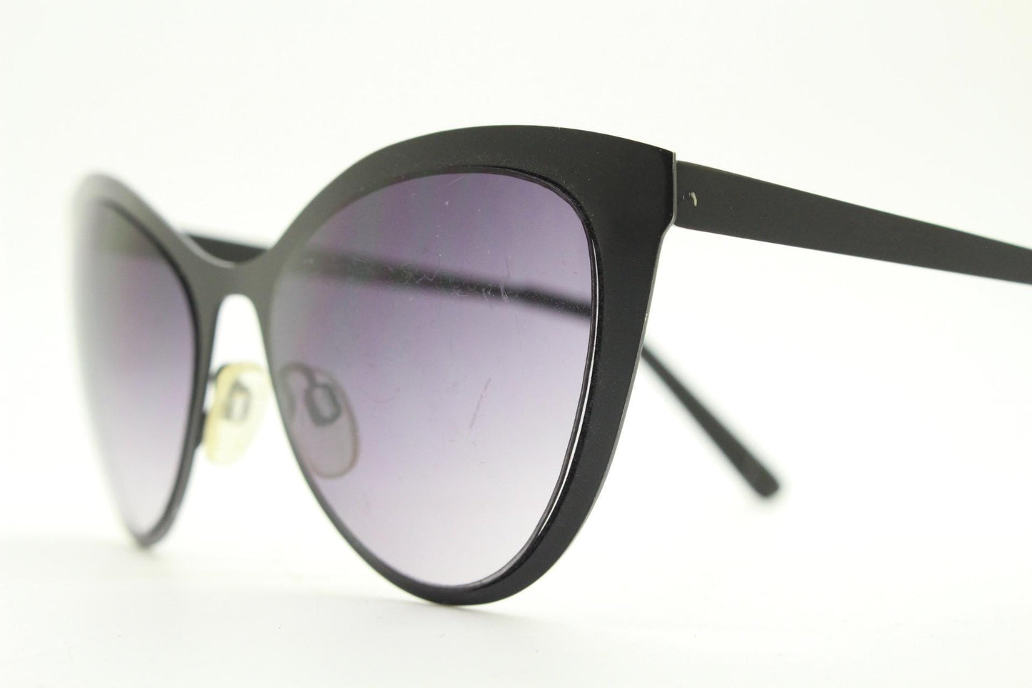 Vintage pointed cat eye sunglasses. Flat metal frame in a satin finish encasing smoky grey graduating lenses. Womens cateye