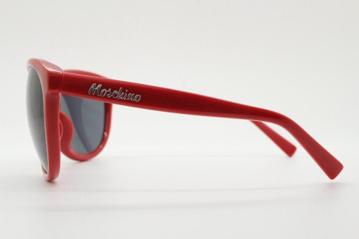 Moschino oversized Y2K vintage sunglasses. Characteristic crimson red acetate frame with cut out heart bridge. 2000s
