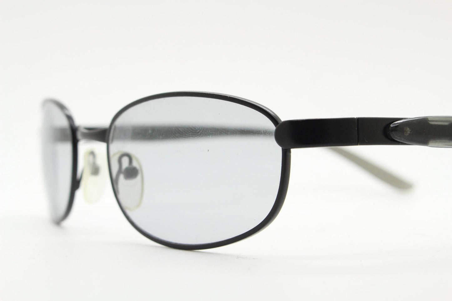 90s vintage oval small bug eye sunglasses. Curved black satin finish metal frame with transparent grey arms and light tone lenses. NOS