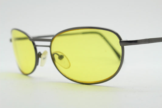 Y2K vintage small oval bug eye sunglasses. Gunmetal grey satin finish frame with blazing canary yellow lenses. Unused 2000s NOS. 90s micro