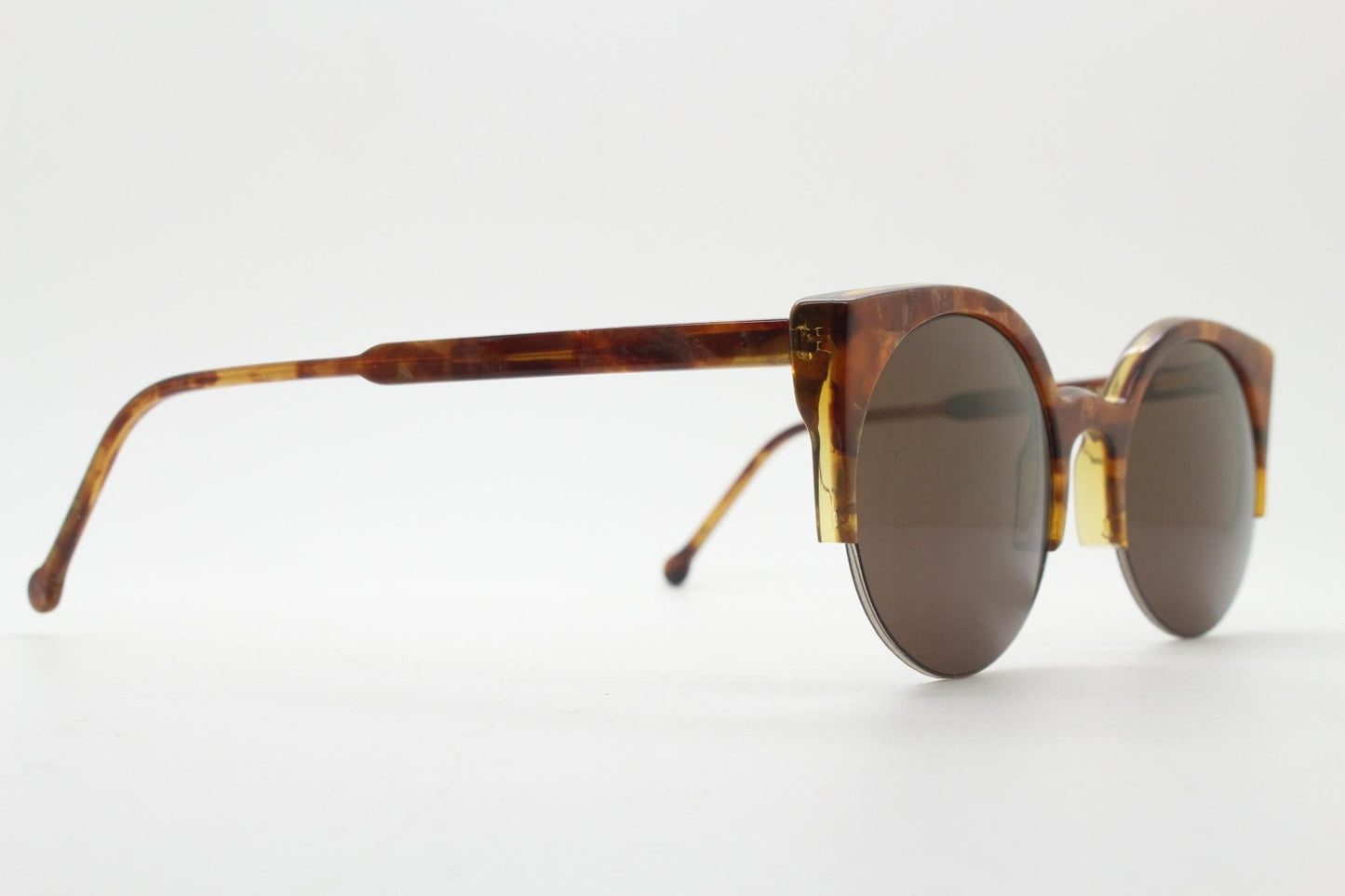 Retrosuperfuture vintage angular cat eye sunglasses made in Italy. Marbled brown gloss acetate flat top half frame with round lenses