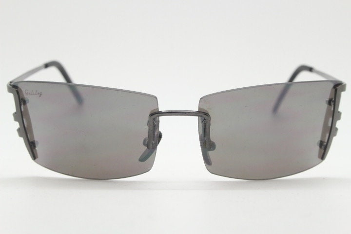 Y2K vintage wraparound sunglasses. Dynamic frameless shield design in gunmetal grey with slight mirror glaze rectangular lenses. 2000's NOS
