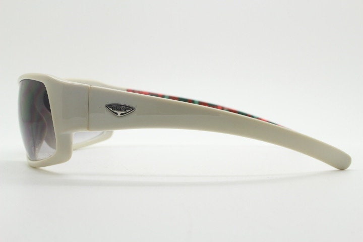 Uvex Y2k vintage wrap around bug eye sunglasses. Curving white sports shield frame with black lenses and tartan interior. Rave 2000s. NOS