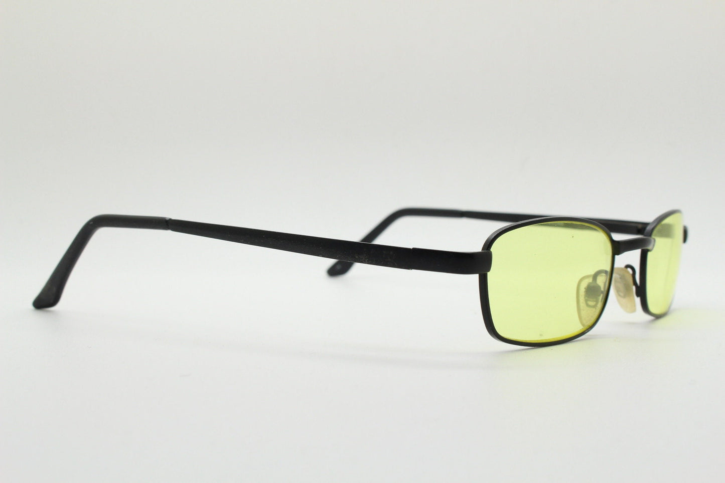 90s vintage small rectangular sunglasses. Minimal plain black matt metal frame with bright yellow lenses. Steampunk. Micro