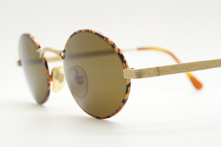 Armandos 90s vintage oval sunglasses made in Italy. Enamelled honey tortoise front with ornate tooled metal arm patterns. NOS
