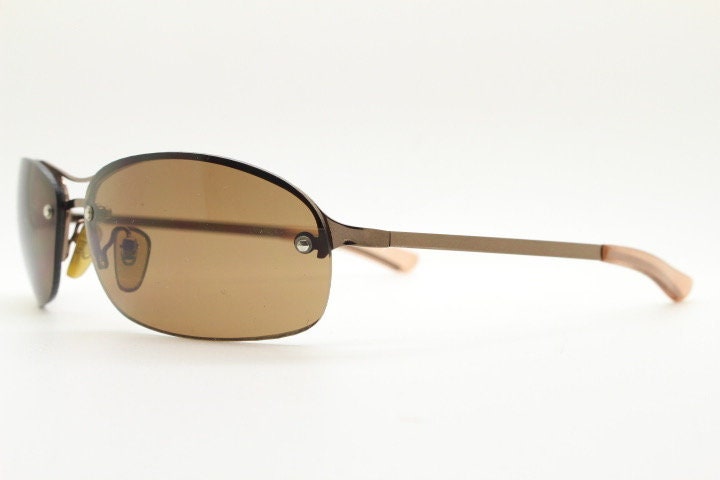 Y2K vintage oval aviator sunglasses. Metallic brown chrome half frame with mid tone curved bug eye lenses and straight arms. 2000's. NOS
