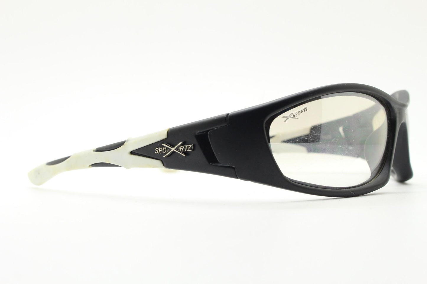 90s vintage sports sunglasses. Black matt aerodynamic wraparound with straight white rubber arms and light tone lenses. Y2K rave shield