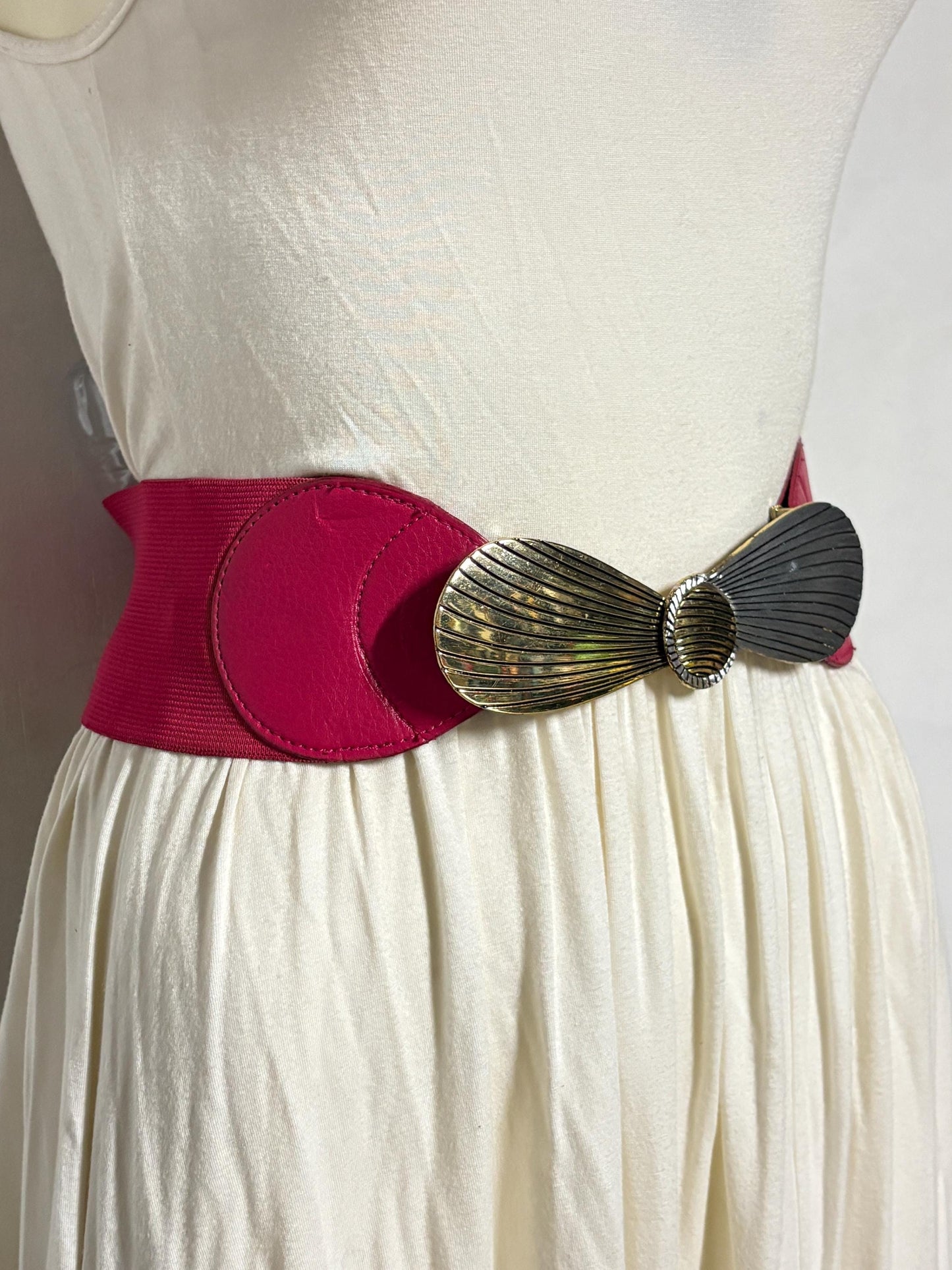 80s vintage womens tall pink elastic belt. Large winged silver and gold buckle. Flattering cinch effect. Adjustable stretchy size range