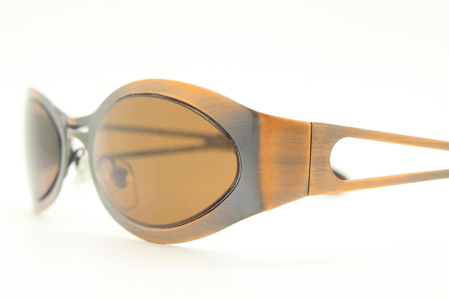 2000s vintage wraparound angular sunglasses. brushed copper finish flat curved metal frame with cut out arms. 90s. Y2K unused NOS