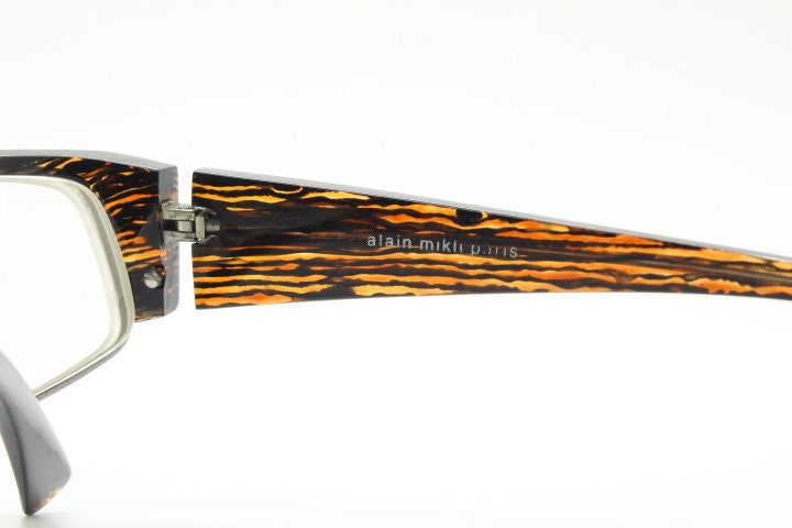 Alain Mikli 90s vintage eye glasses hand made in France. Low profile wrap around half frame in 'wood grain' acetate. Optical prescription RX