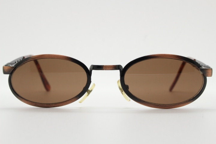 90s vintage oval sunglasses. Handsome metallic brushed copper finish with arm cut outs. Unused NOS