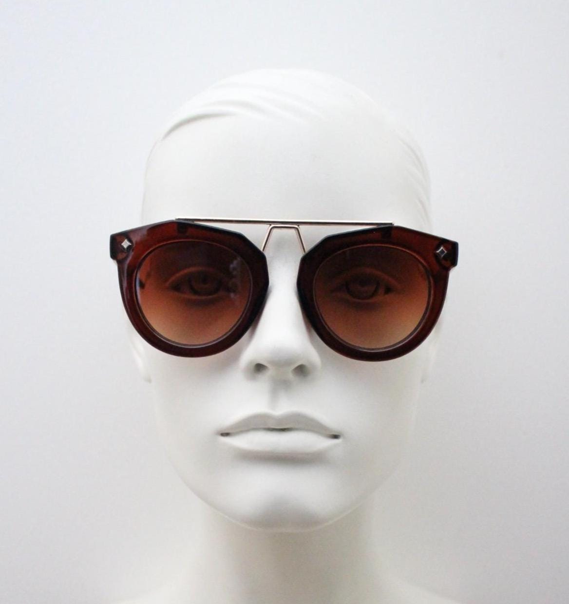 Rounded cateye sunglasses with gold 'scaffold' metal bridge. Women's transparent frame with matching brown graduating lenses. Vintage NOS