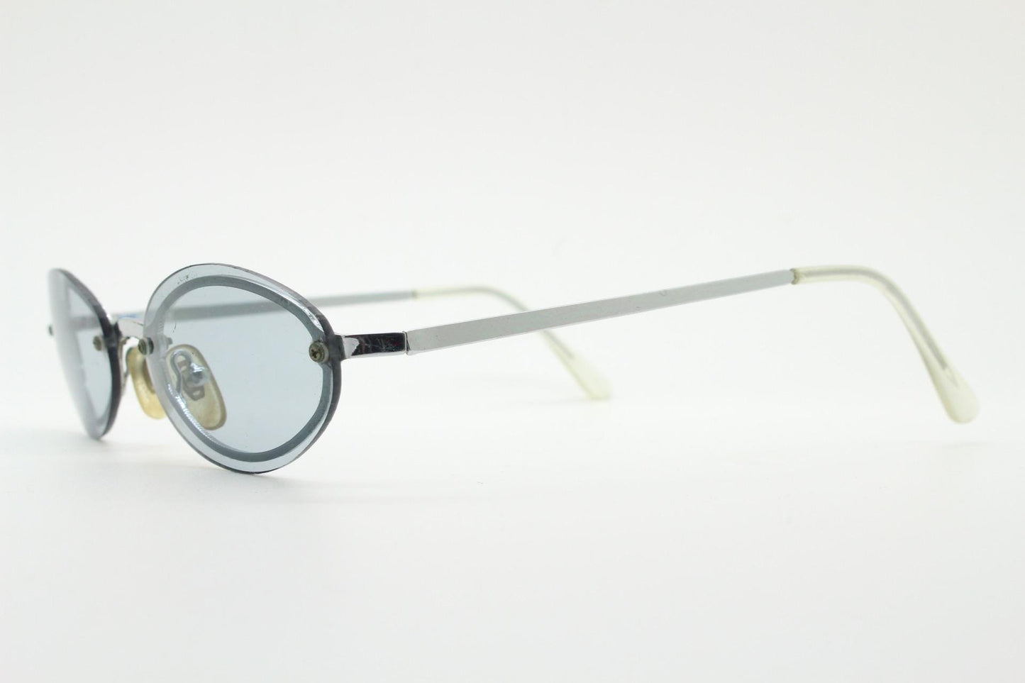 90s vintage small oval sunglasses. Minimal silver chrome metal frame with overlapping light tone grey lenses. Micro. Steampunk