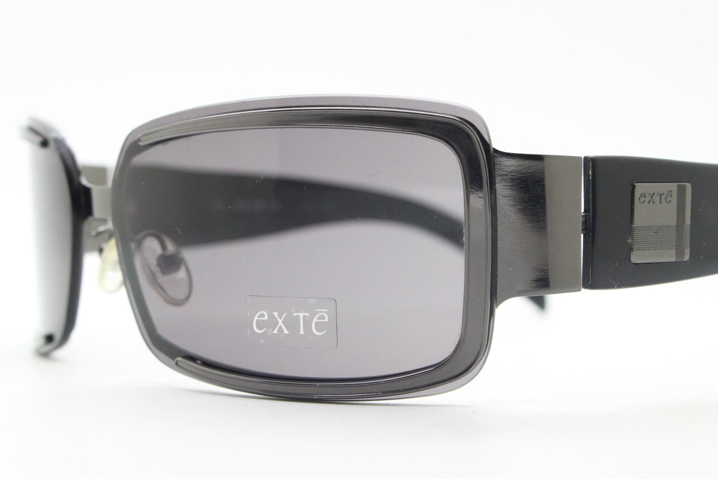 Exte wrap around 90s vintage sunglasses made in Italy. Grey metal front with black acetate arms and curved lenses in neat proportions. BNWT