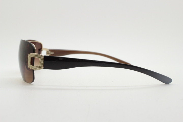 Y2K vintage rectangular brown sunglasses. Gold half frame 2000's wrap around with curved lenses, gold trim and temple crests. Unused NOS