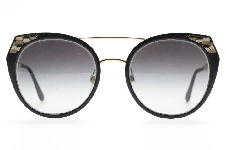 Bulgari round cropped cat eye sunglasses made in Italy. Womens black and gold frame with honeycomb patterns and smoky graduating lenses