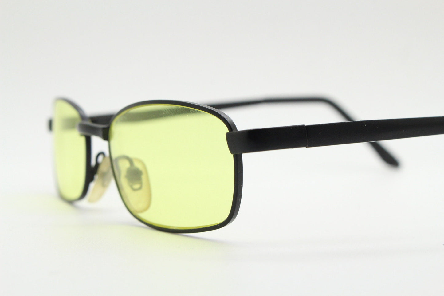 90s vintage small rectangular sunglasses. Minimal plain black matt metal frame with bright yellow lenses. Steampunk. Micro